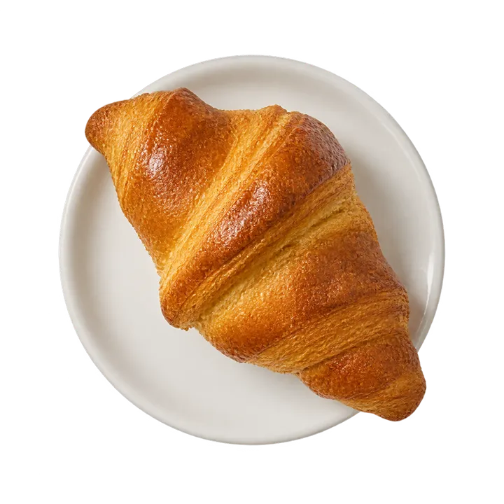 Un croissant doré sur une petite assiette